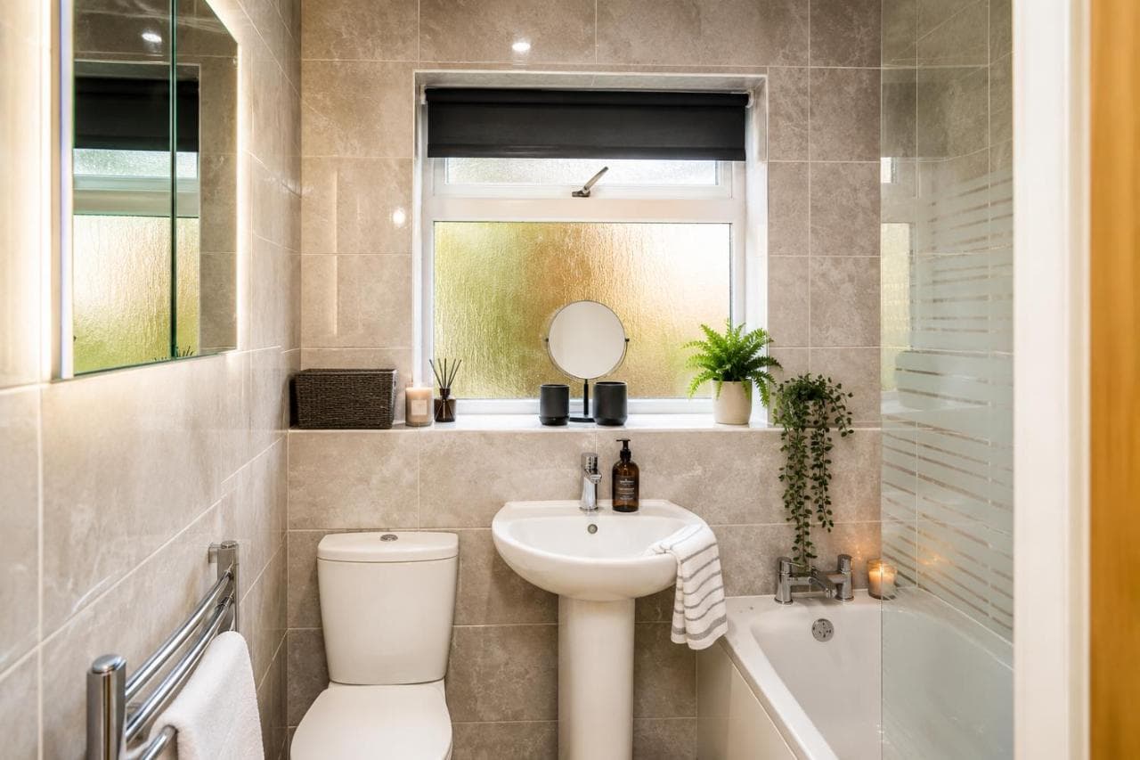Bathroom with bath, shower screen and heated towel rail at St George's House